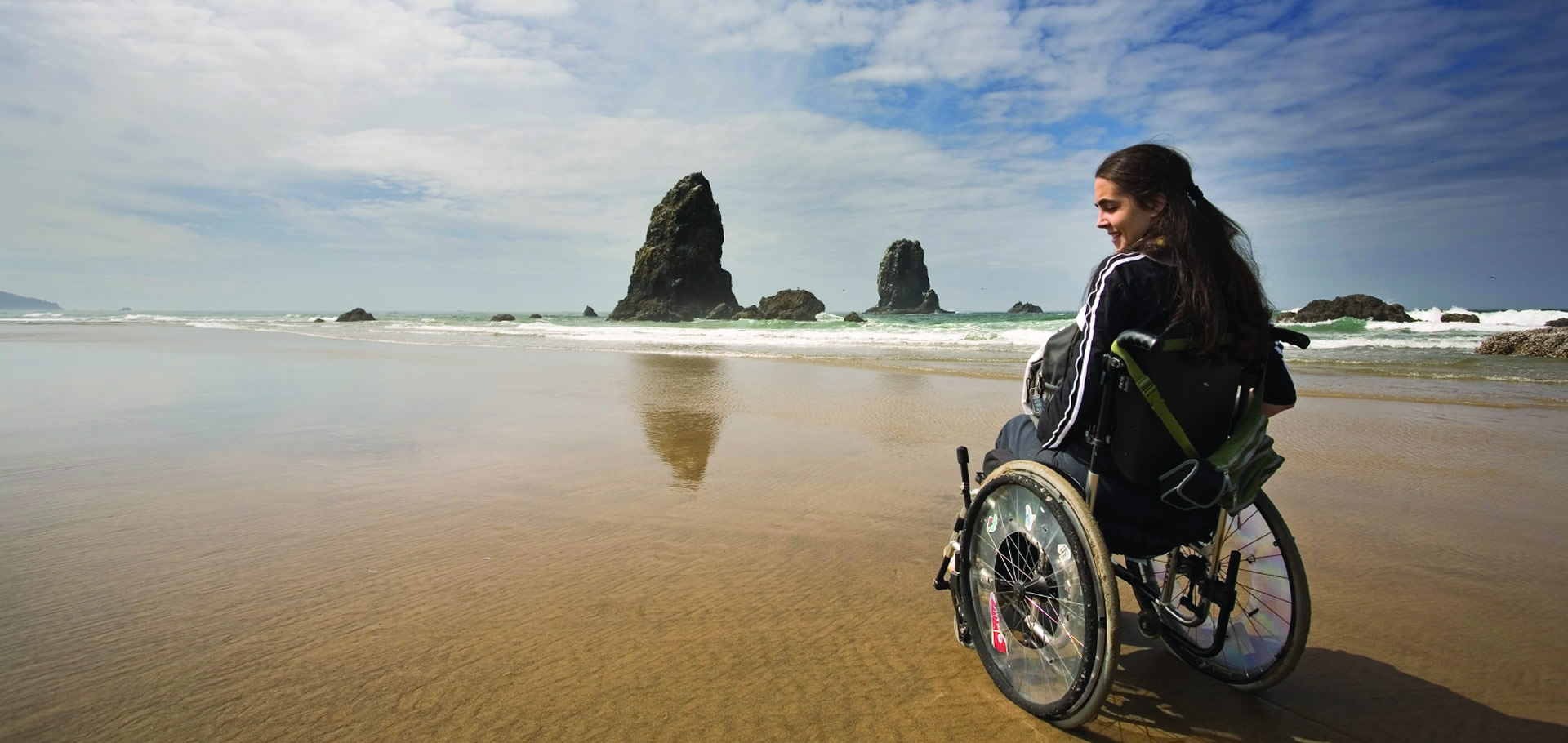 a woman on a wheelchair sitting near the shore